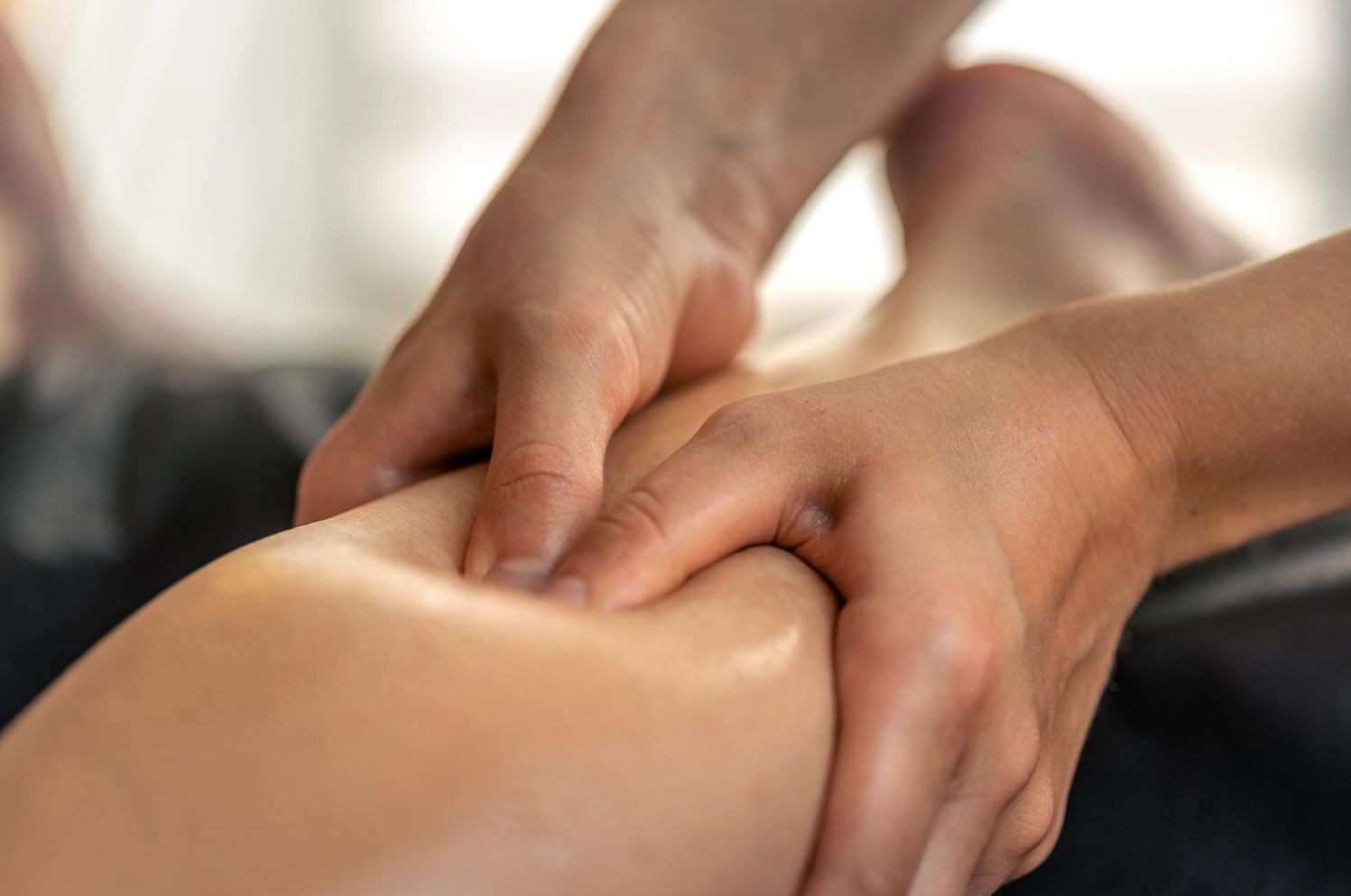 Gentle hands and warm oil on a guest's arm — aromatherapy massage at Golden SPA Lake Forest
