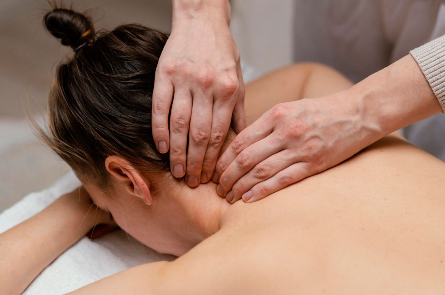 Therapist working on a guest's neck and upper shoulders to release tension