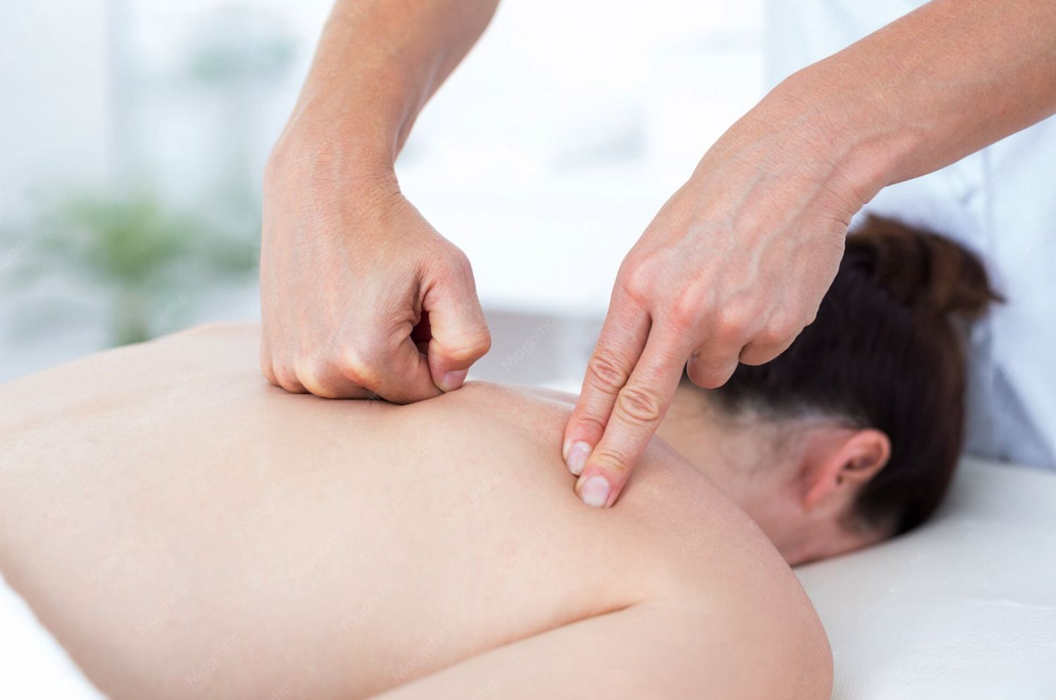 Therapist applying focused pressure on a guest's upper back and neck at Golden SPA Lake Forest